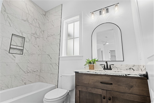 full bathroom featuring toilet, ceiling fan, tiled shower / bath combo, and vanity