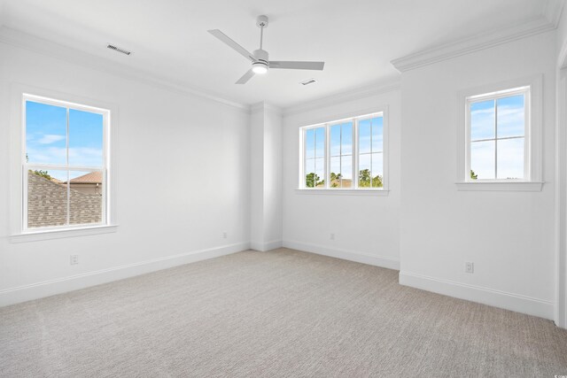 empty room with ceiling fan, light carpet, and crown molding