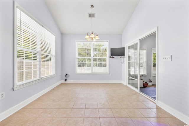 tiled spare room with an inviting chandelier and vaulted ceiling