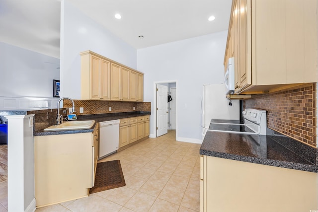 kitchen with white appliances, sink, decorative backsplash, light tile patterned floors, and kitchen peninsula