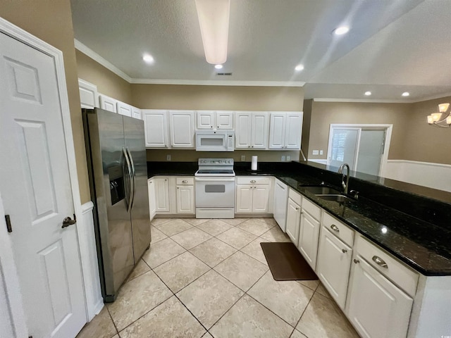 kitchen with sink, white appliances, dark stone counters, and white cabinets