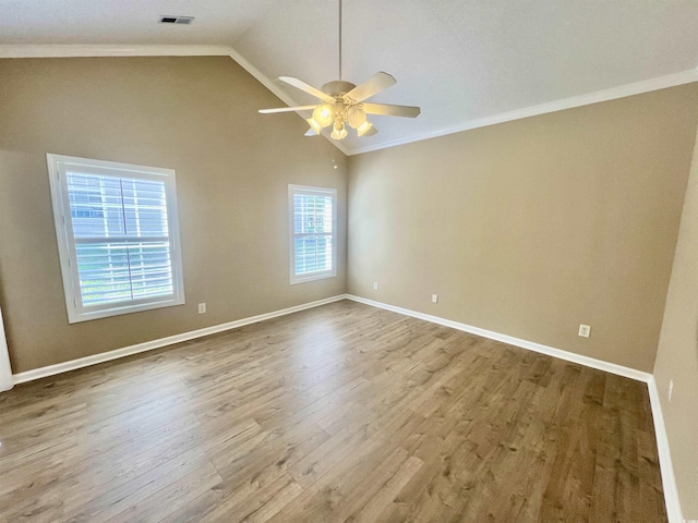 spare room featuring crown molding, ceiling fan, lofted ceiling, and light hardwood / wood-style flooring