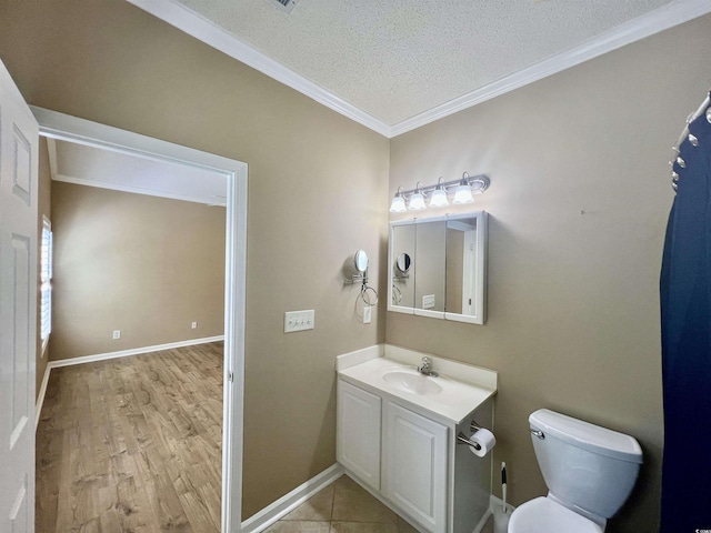 bathroom featuring toilet, a textured ceiling, ornamental molding, vanity, and hardwood / wood-style flooring