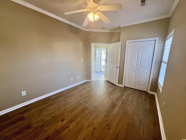 unfurnished bedroom featuring crown molding, hardwood / wood-style floors, ceiling fan, and a closet