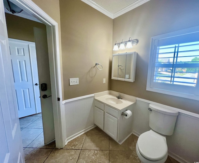 bathroom featuring vanity, tile patterned flooring, ornamental molding, and toilet