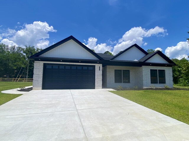 205 Brush Ct, Little River, SC 29566 - view of front of property featuring concrete driveway, an attached garage, and brick siding