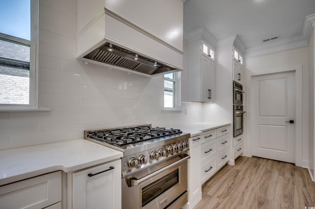 205 Brush Ct, Little River, SC 29566 - kitchen with custom range hood, stainless steel appliances, white cabinetry, glass insert cabinets, and backsplash