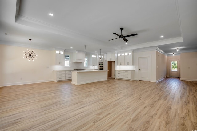205 Brush Ct, Little River, SC 29566 - unfurnished living room with a tray ceiling, ornamental molding, recessed lighting, a ceiling fan, and a chandelier
