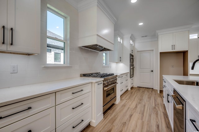 205 Brush Ct, Little River, SC 29566 - kitchen with stainless steel appliances, premium range hood, white cabinetry, crown molding, and light countertops