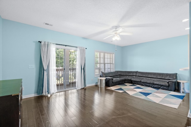 unfurnished living room featuring a textured ceiling, dark hardwood / wood-style flooring, and ceiling fan