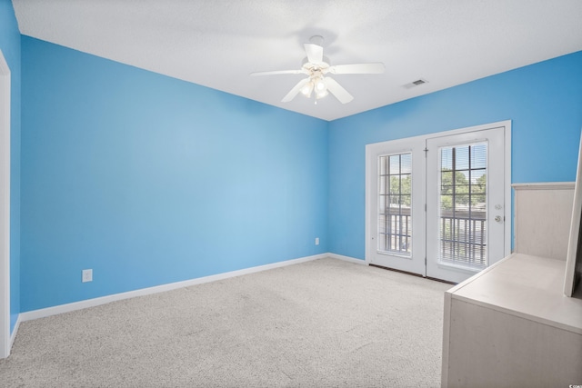 carpeted spare room featuring ceiling fan