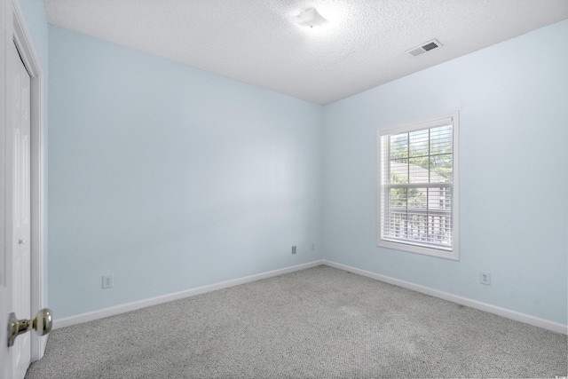 unfurnished room featuring carpet flooring and a textured ceiling