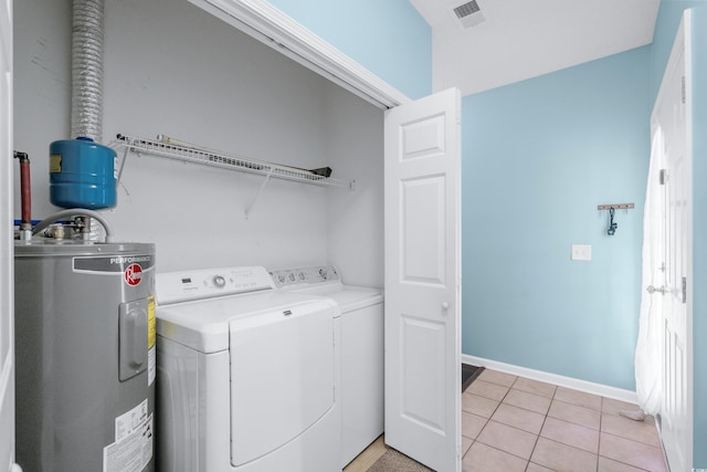 laundry area with washing machine and dryer, electric water heater, and light tile patterned flooring