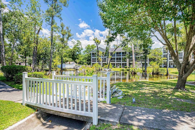 surrounding community featuring a water view and a lawn