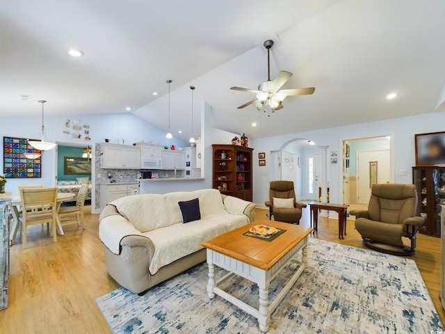 living room featuring vaulted ceiling, light hardwood / wood-style flooring, and ceiling fan