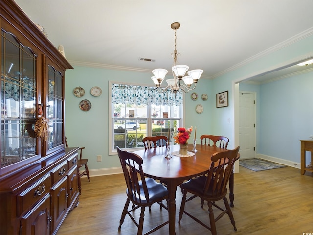 dining room featuring light hardwood / wood-style flooring, a notable chandelier, and crown molding