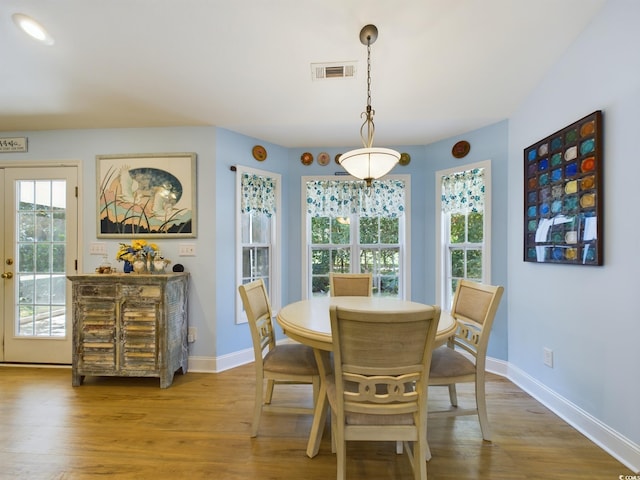 dining room with hardwood / wood-style flooring and a healthy amount of sunlight