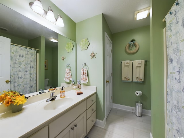 bathroom with vanity, toilet, and tile patterned floors