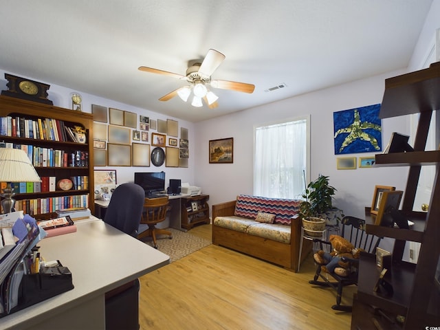 home office with light wood-type flooring and ceiling fan