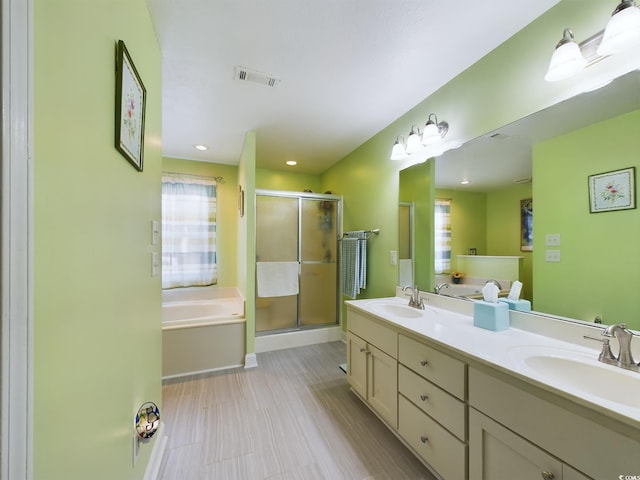 bathroom featuring vanity and independent shower and bath