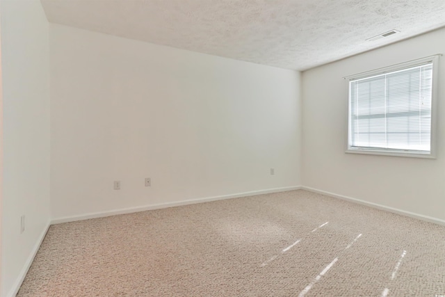 carpeted empty room with a textured ceiling