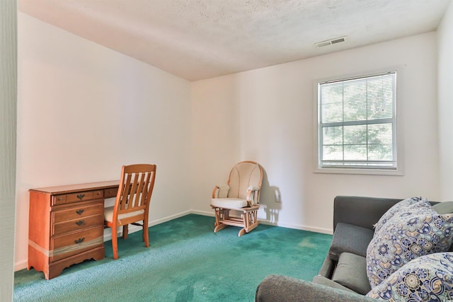 sitting room featuring carpet flooring and a textured ceiling