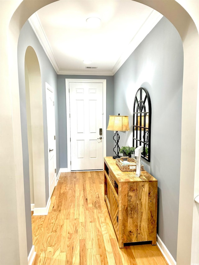 doorway to outside featuring hardwood / wood-style floors and crown molding