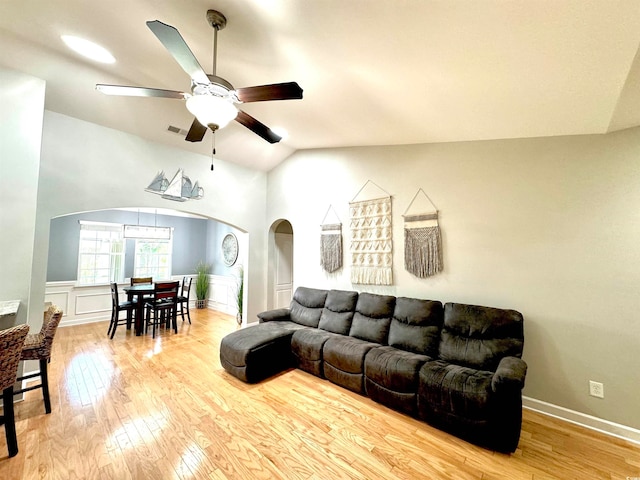 living room featuring ceiling fan, light hardwood / wood-style floors, and lofted ceiling