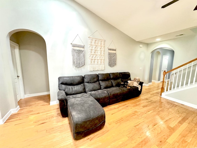 living room featuring lofted ceiling, ceiling fan, and light hardwood / wood-style flooring