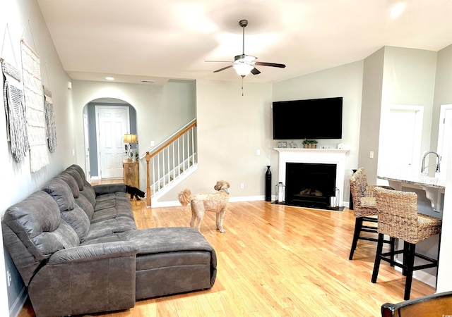 living room featuring hardwood / wood-style floors, sink, and ceiling fan