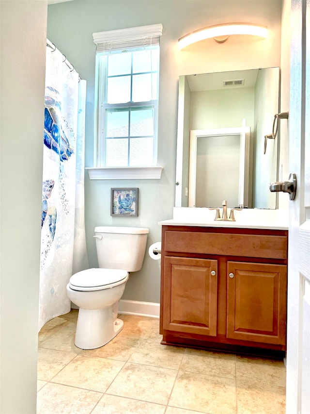 bathroom with tile flooring, toilet, and vanity