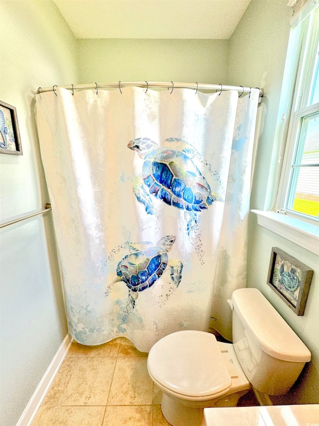 bathroom featuring tile flooring and toilet