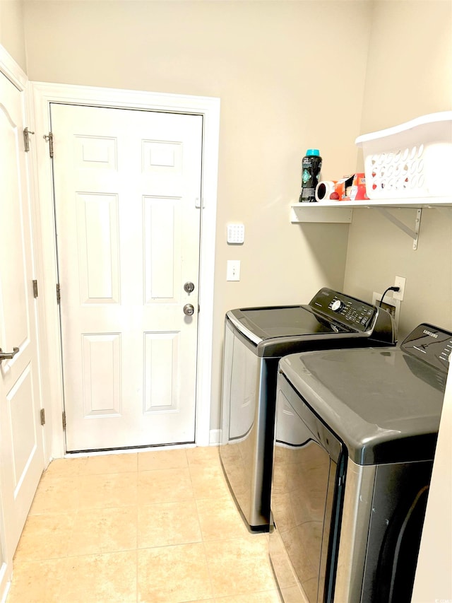 laundry area featuring washing machine and dryer, light tile flooring, and washer hookup