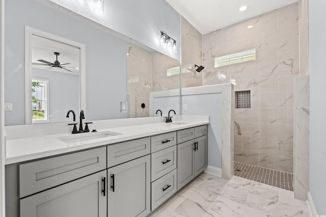 bathroom featuring ceiling fan, a tile shower, and vanity