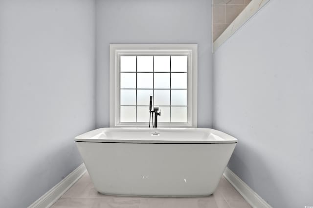 bathroom with a wealth of natural light and a bathtub