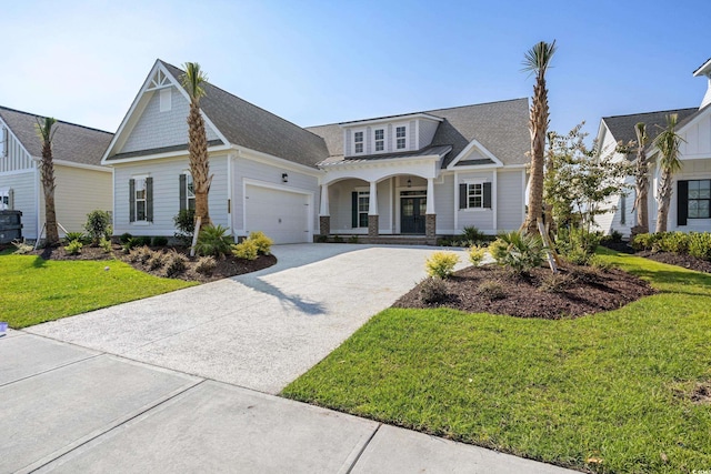 view of front of house featuring a porch, a garage, and a front yard