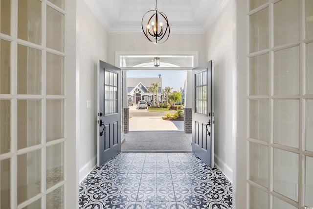 foyer entrance with an inviting chandelier, ornamental molding, and french doors