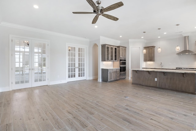 unfurnished living room with french doors, crown molding, and light hardwood / wood-style flooring