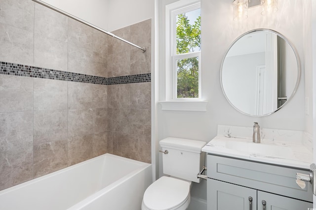 full bathroom with tiled shower / bath combo, vanity, and toilet