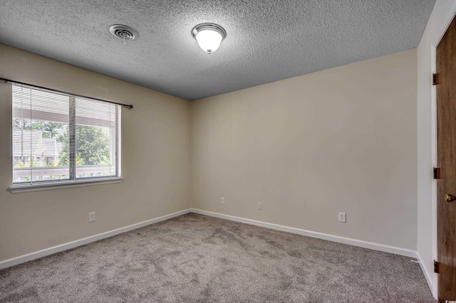 carpeted spare room with a textured ceiling