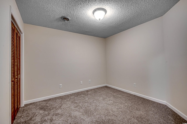 carpeted spare room featuring a textured ceiling