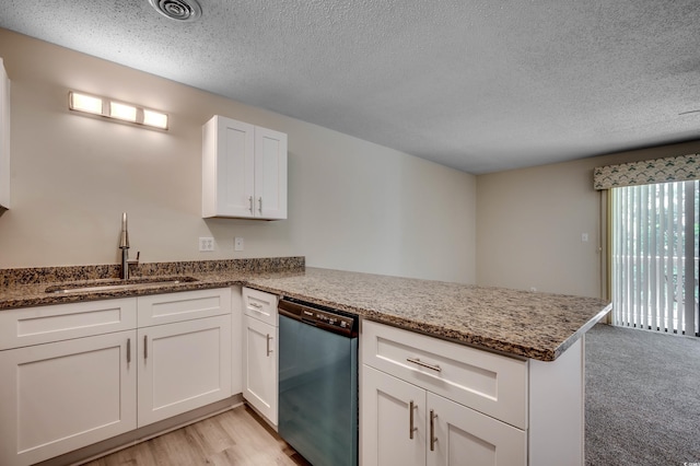 kitchen with stainless steel dishwasher, kitchen peninsula, and sink