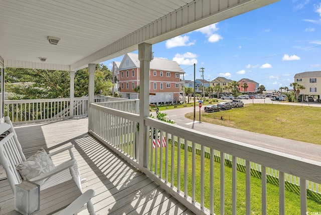 wooden terrace with a porch and a yard