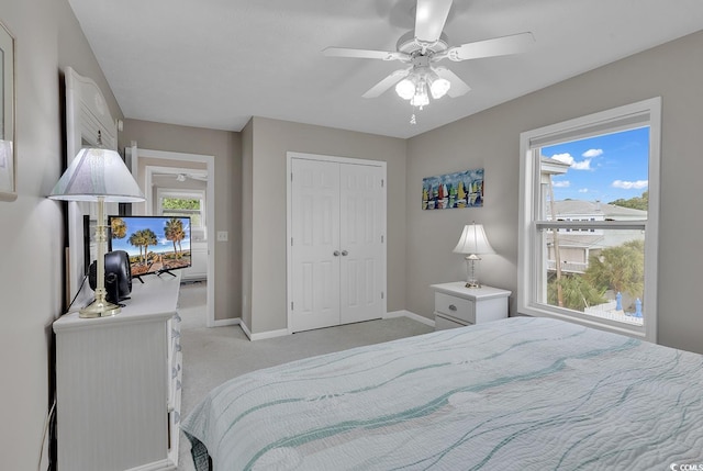 bedroom featuring ceiling fan, a closet, and light colored carpet