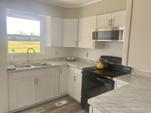 kitchen with sink, dark hardwood / wood-style flooring, black electric range, white cabinets, and ornamental molding