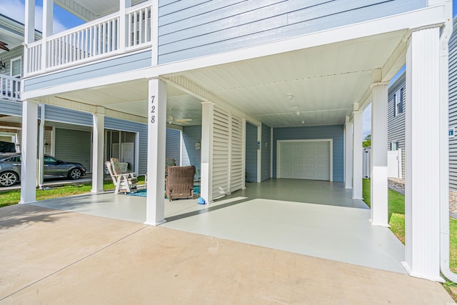 view of patio featuring a balcony, a garage, and a carport