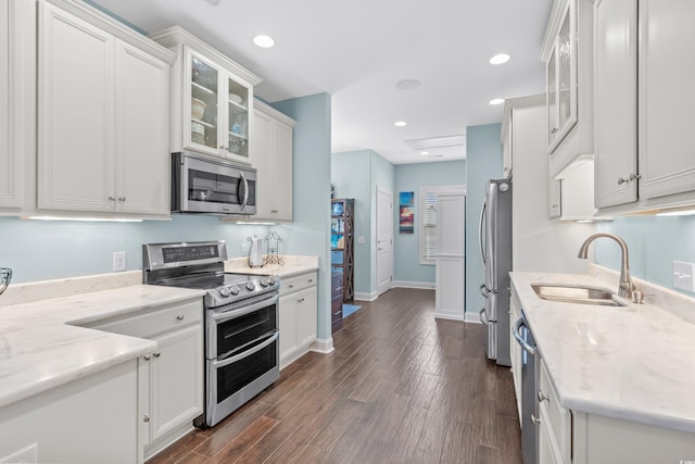 kitchen featuring white cabinets, stainless steel appliances, light stone counters, and sink