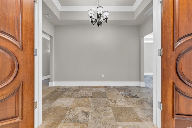 entryway with crown molding, a chandelier, and a tray ceiling