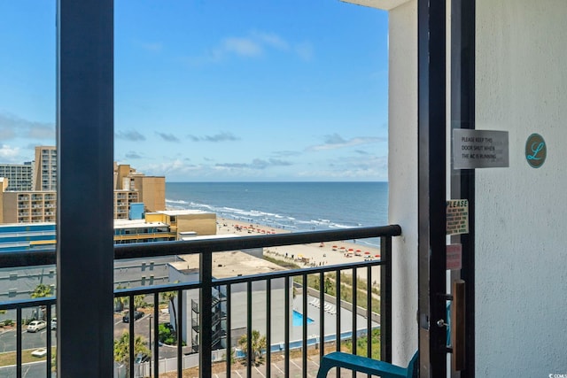 balcony featuring a water view and a beach view