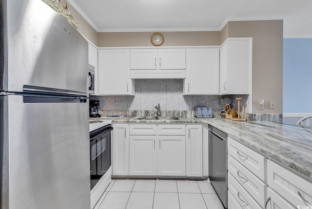 kitchen featuring tasteful backsplash, light tile floors, sink, white cabinetry, and appliances with stainless steel finishes